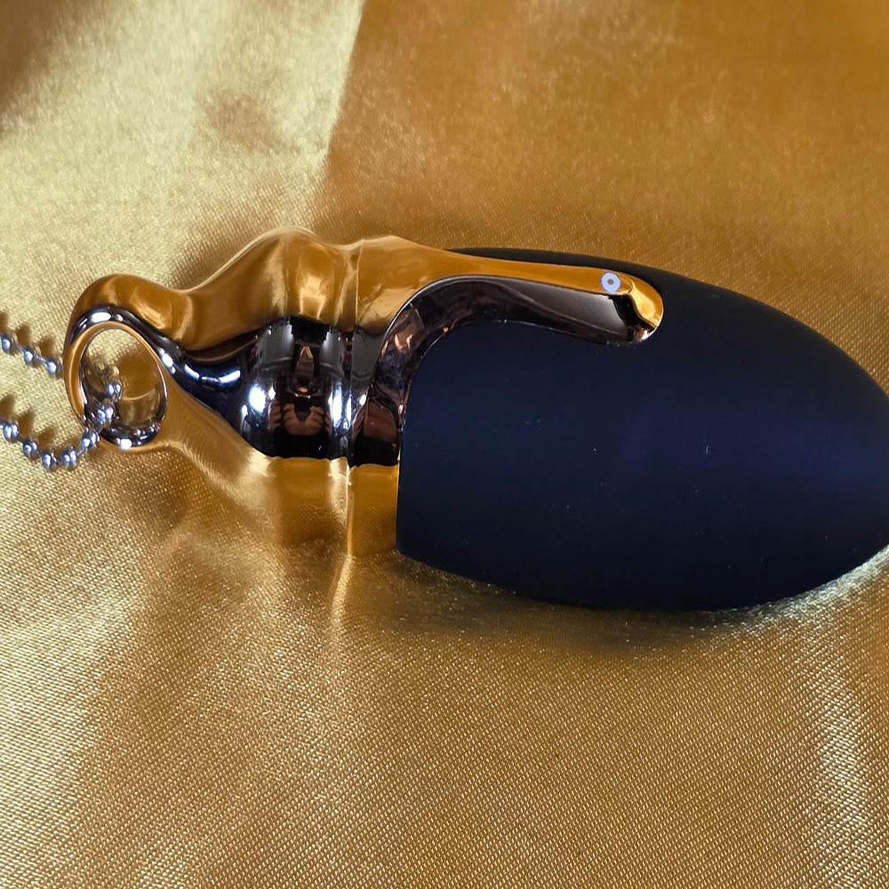 Betty Bullet guldsmycke vibrator liggande på guldbakgrund – Chambers of Love