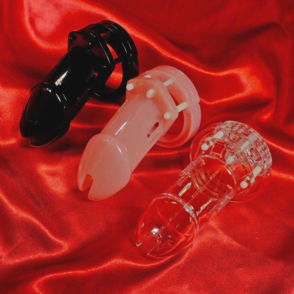 CB-6000 kyskhetsbälte för män i tre färger – transparent, svart och rosa – visade framifrån på röd bakgrund från Chambers of Love