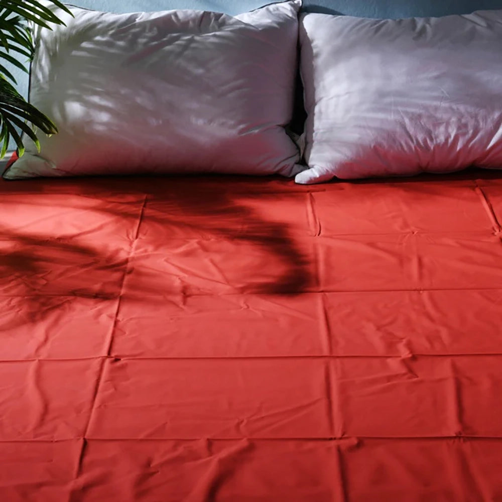 Lacklakan 200 x 220 cm från Chambers of Love i röd färg på säng med skyddande yta för Nuru massage och våta stunder