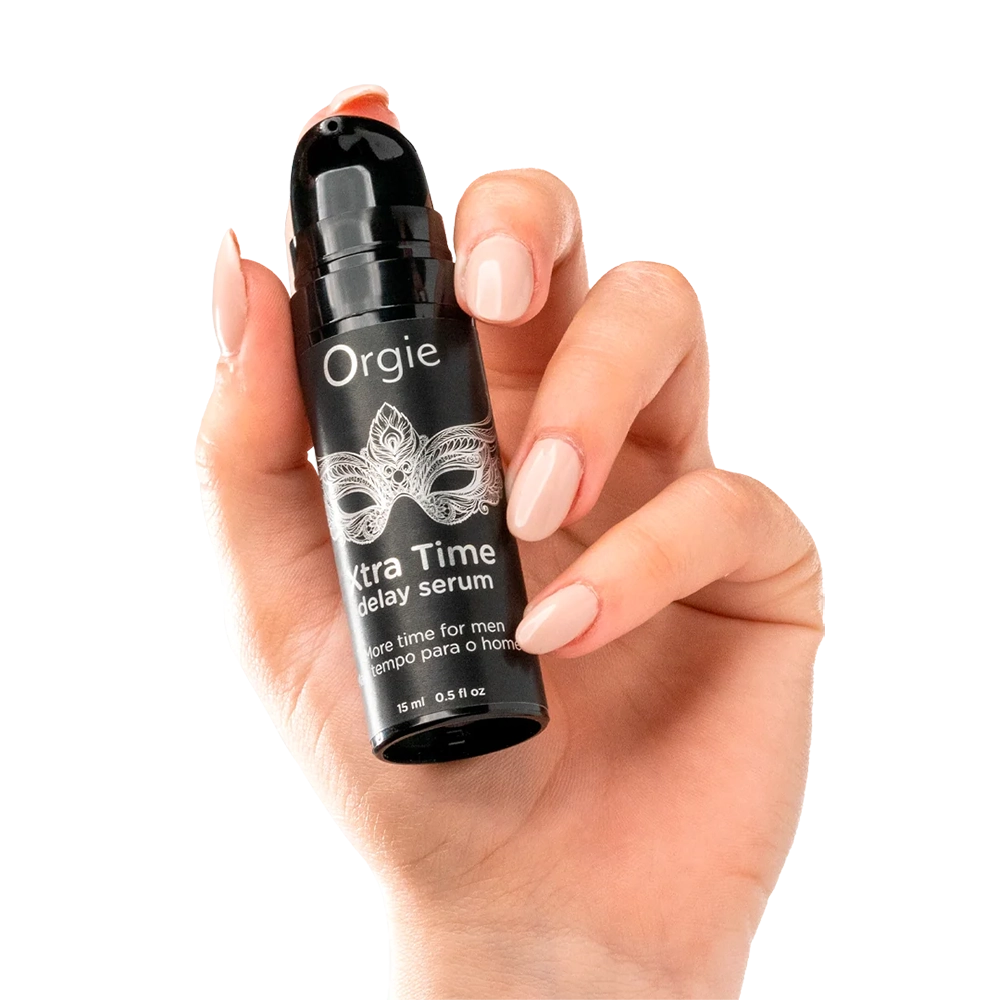 Hand som håller Orgie XtraTime Delay Serum flaska med pumpdispenser och transparent bakgrund från Chambers of Love