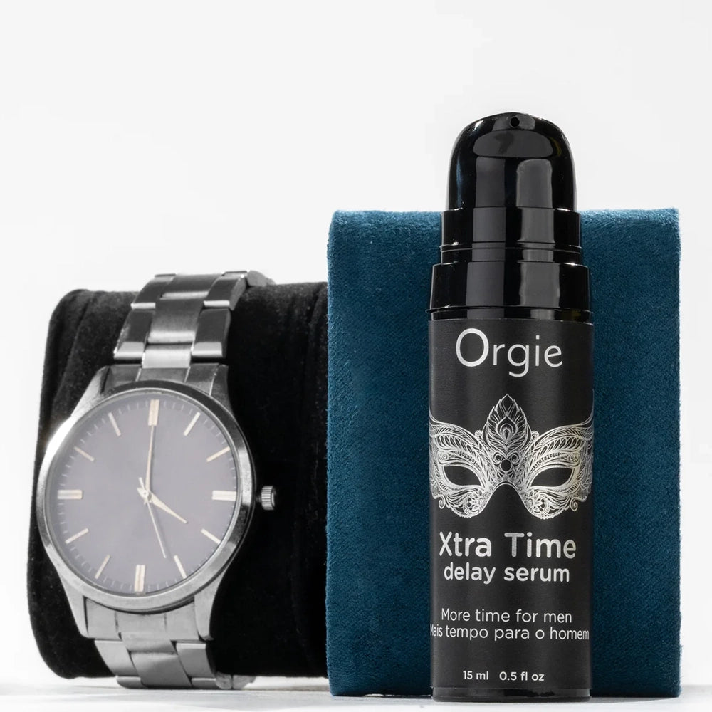 Orgie XtraTime Delay Serum flaska med armbandsur som visar tids fördröjning på vit bakgrund från Chambers of Love