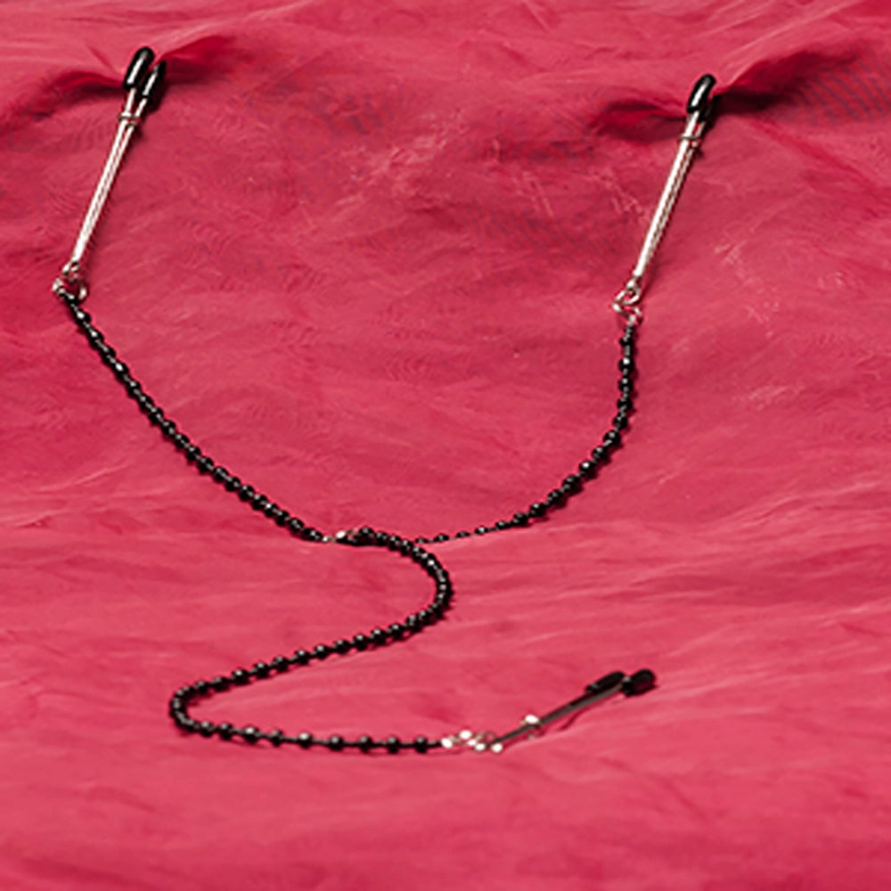 Justerbara bröst- och klitorisklämmor med svart kedja och silverfärgade klämmor för BDSM hos Chambers of Love